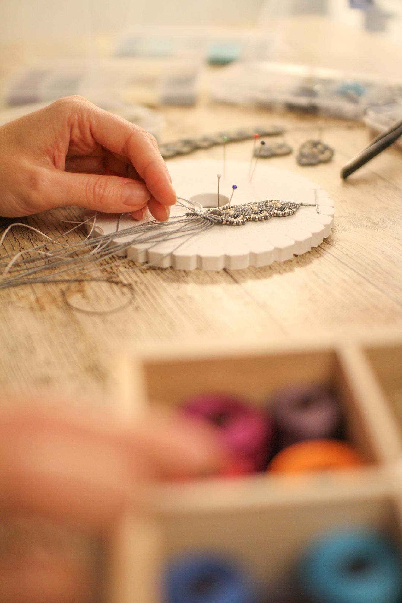 atelier hands stitching a linen panel